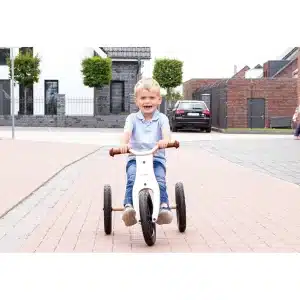 Barn kører på Pinolino Oskar 2-i-1 trehjulet cykel i hvid/natur på en rolig vej.