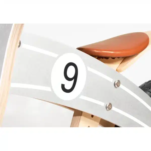 Detaljebillede af Pinolino Nico løbecykel i sølv/natur med brunt sæde og nummer 9 på siden.