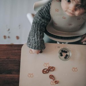 Barn med hagesmæk ved Noui Noui dækkeserviet Breze med kringler og snacks