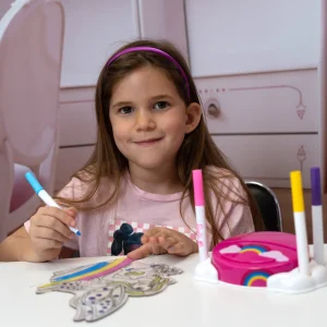 Barn farvelægger motivet til en Barbie natlampe med tusser ved bordet