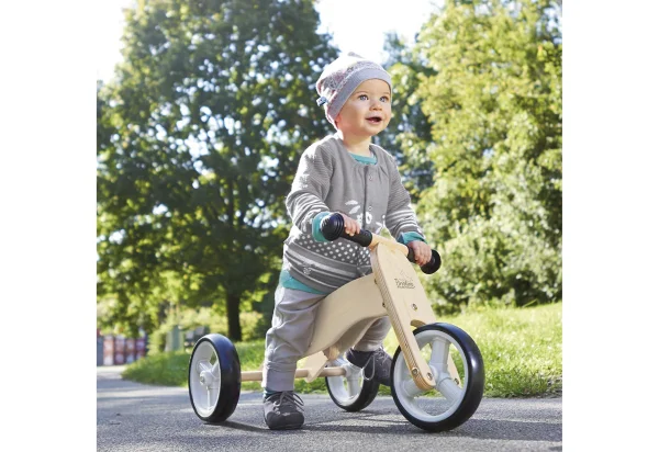 Barn på Pinolino Charlie løbecykel i naturtræ med tre hjul på en sti