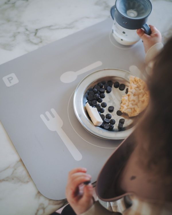 Barn spiser morgenmad på Noui Noui lær at dække bord Grey med omrids til bestik