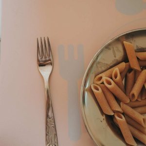 Gaffel og tallerken med pasta på Noui Noui læringsdækkeserviet Nude