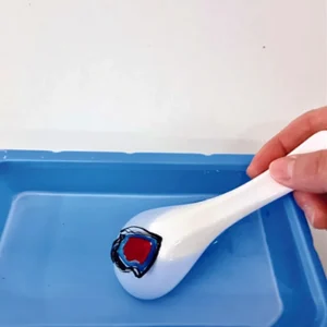 En dekoreret keramisk ske dyppes i en blå bakke med vand – Paw Patrol Floating Art