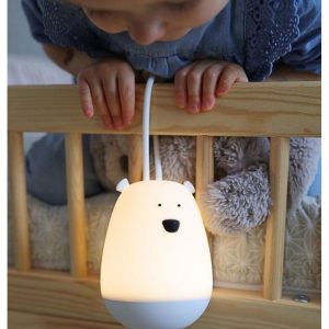 Barn ser på en lysende bjørn natlampe med ophæng fra Rabbit & Friends på en træseng.