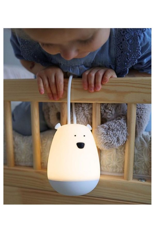 Barn ser på en lysende bjørn natlampe med ophæng fra Rabbit & Friends på en træseng.
