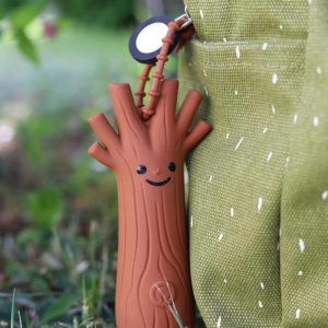 Rabbit & Friends mini lommelygte TED med tændt lys hængende ved grønt stof udendørs