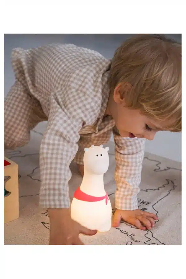 Giraf natlampe med tørklæder fra Rabbit & Friends lyser ved siden af et barn